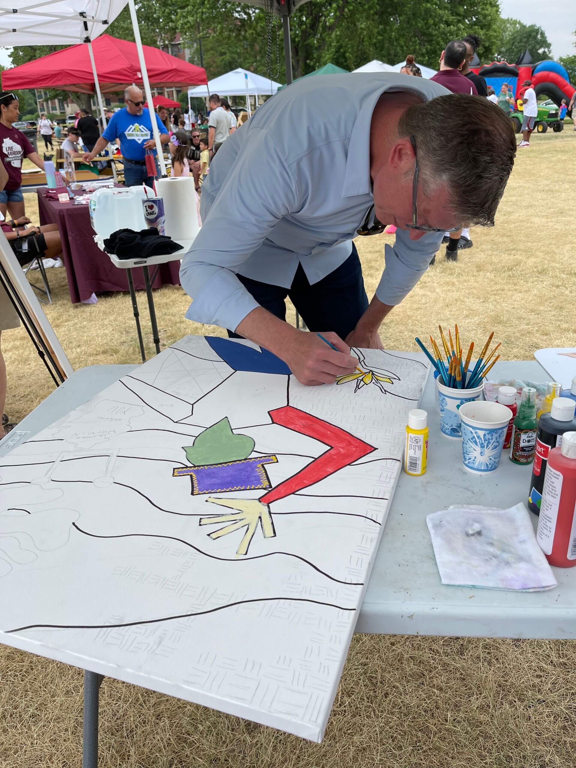 man at Juneteenth La Crosse works on art project