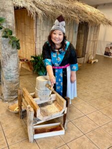 Mai-Tia-Yang-of-the-Hmong-Cultural-Community-Center-demonstrates-how-to-use-a-Hmong-corn-grinder-during-the-Hmong-Education-Project