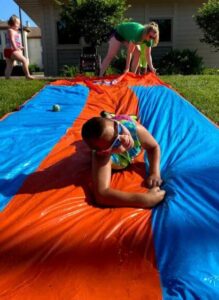 A camper slides down a slip and slide